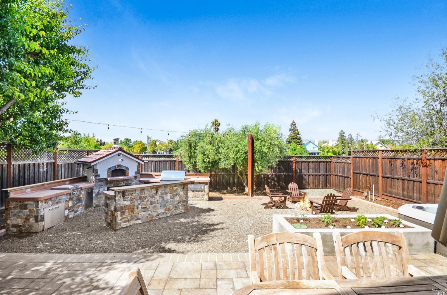Backyard over looking the custom kitchen and fire pit. Don't miss the open views