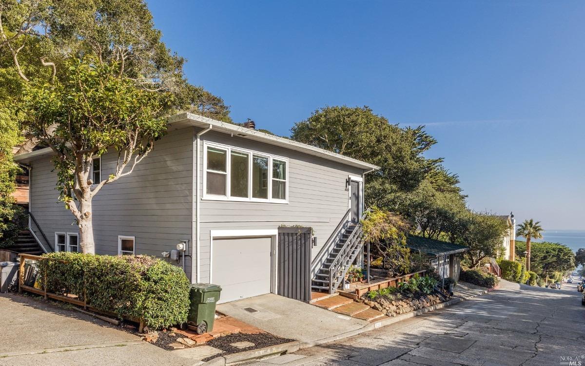 Wonderfully bright & sunny mid-century modern home with a unique suite of features includes beautiful Views of the Bay, Bridges, & Alcatraz, large fenced / landscaped yard, private back deck, 2-car tandem garage, & an income-producing rental. You'll be treated to stunning sunrises over coffee from the front porch or from inside the open-concept living area via the new extra-large picture window. Greenery abounds from every vantage of the home, enhancing the already beautiful & serene setting. The bright & sunny main home comprises the upper level with 2 beds, 1.5 baths & a light filled solarium / office w/views into the beautiful backyard. Hardwood floors, a recently remodeled kitchen w/all stainless appliances, updated modern bath w/heated floors, wood burning fireplace & great flow. Enjoy Sausalito evenings in the outdoor atrium w/elegant bistro lighting. This leads to the backyard w/recently added premium turf yard for sought-after flat space for kids, pets, & outdoor fun-a rarity in this area. The magical lower studio has classic hardwood floors, cute / updated kitchen, large updated bathroom, & water views past a private outdoor patio. This little slice of paradise is close to Swedes Beach, downtown, caf's, restaurants, the Headlands & minutes by car into SF.