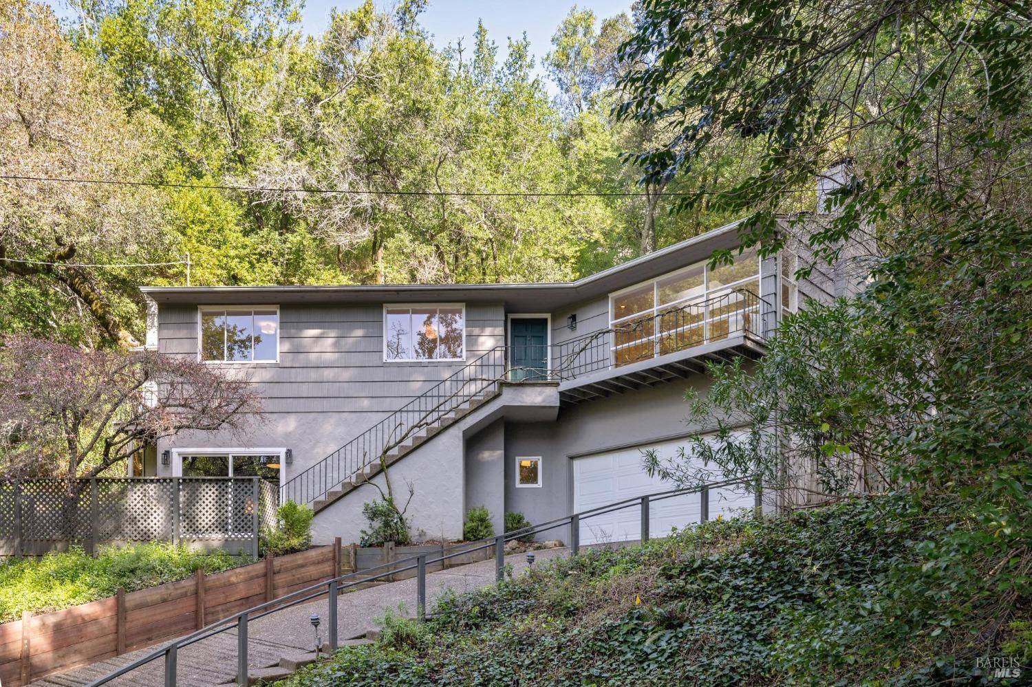 Located in the highly sought-after Winship Park neighborhood of Ross, this mid-century home at 95 Wellington Avenue offers a perfect blend of style and comfort. The residence spans across two levels and features 4 bedrooms,2.5 bathrooms, and a total living area of approx. 2,300 sq ft on a lot of over 13,000 sq ft, providing a spacious and timeless living experience. The living room is spacious and offers stunning views of the valley, a wood-burning fireplace, refinished hardwood floors, and skylight that creates a warm and welcoming atmosphere. The adjacent dining room has open shelving, cabinetry, and French doors that lead to a large rear entertaining patio, perfect for indoor-outdoor living. The kitchen is a chef's dream, with ample custom cabinetry and storage space, a pantry, a Wolf Range, a dishwasher, a refrigerator, and a center island that offers storage and prep space. The primary bedroom features vaulted ceilings, skylights, and an ensuite primary bathroom. Upstairs, there are two more bedrooms with refinished oak floors and spacious closets. The lower floor bedroom and half bathroom, with its entrance to a private yard, offer flexibility and can be used as a home office or guest room. The home also features a garage with an automatic door and interior access.