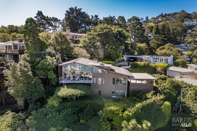 Welcome to 74 Cloud View Road, where mid-century chic meets luxury living in Sausalito! This architectural gem offers unparalleled, unobstructed sweeping water views that will take your breath away. The open-concept living/dining area is an entertainer's dream, providing the perfect backdrop for sophisticated entertaining or casual gatherings. Soaring ceilings and elegant floor-to-ceiling windows frame the stunning view, a living masterpiece that changes with the hues of the day. A chic wet bar adorned with mid-century cabinetry completes the room. The crow's nest loft perched above the living area offers a retreat with a water view, perfect for a home office or study. A cozy den includes a fireplace with a marble hearth and connects to a well-appointed kitchen featuring stone countertops and a Viking range. Double sliding doors open to a garden patio with a built-in grill, perfect for al fresco dining. Boasting three spacious bedrooms, each with its own ensuite bath and situated on its own level, this residence offers privacy and comfort. Don't miss the bonus room, a versatile space for an artist's studio, workshop, or wine room,  adding another unique layer to this exceptional home. Experience the epitome of Sausalito living at 74 Cloud View Road ... a home not to be missed.