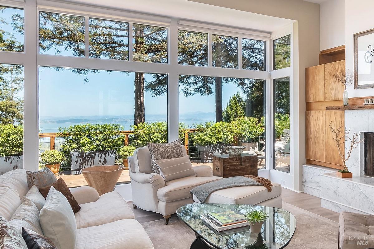 This architecturally stunning custom home with extensive water views of the San Francisco Bay will take your breath away. Designed by owner architect, this masterpiece is set in its own enchanted redwood forest. Enjoy the sense of peace this property provides while being just minutes to downtown Corte Madera/Larkspur. Incredible attention to details throughout. Hand milled doors and cabinetry with curated antique fixtures and old wood beam ceilings make this home a one-of-a-kind treasure. Custom handrails, built in bookcases, ideally placed flagstone, thoughtful landscape lighting and natural hardwood flooring. Three expansive bedrooms, three full bathrooms, plus an office with a view, this home is generously laid out for comfort. The open concept main level of the home features walls of glass with jaw dropping views and a stunning Carrera marble fireplace. The chef's kitchen is dreamy with Calcutta marble, and antique custom cabinetry. French doors connect the living room seamlessly to the expansive view decks for indoor, outdoor living. The property borders the Corte Madera Ridge trail with world class hiking in your backyard. Also located in the acclaimed Tamalpais Union School District.  If you long for something serene, beautiful and private then look no further.