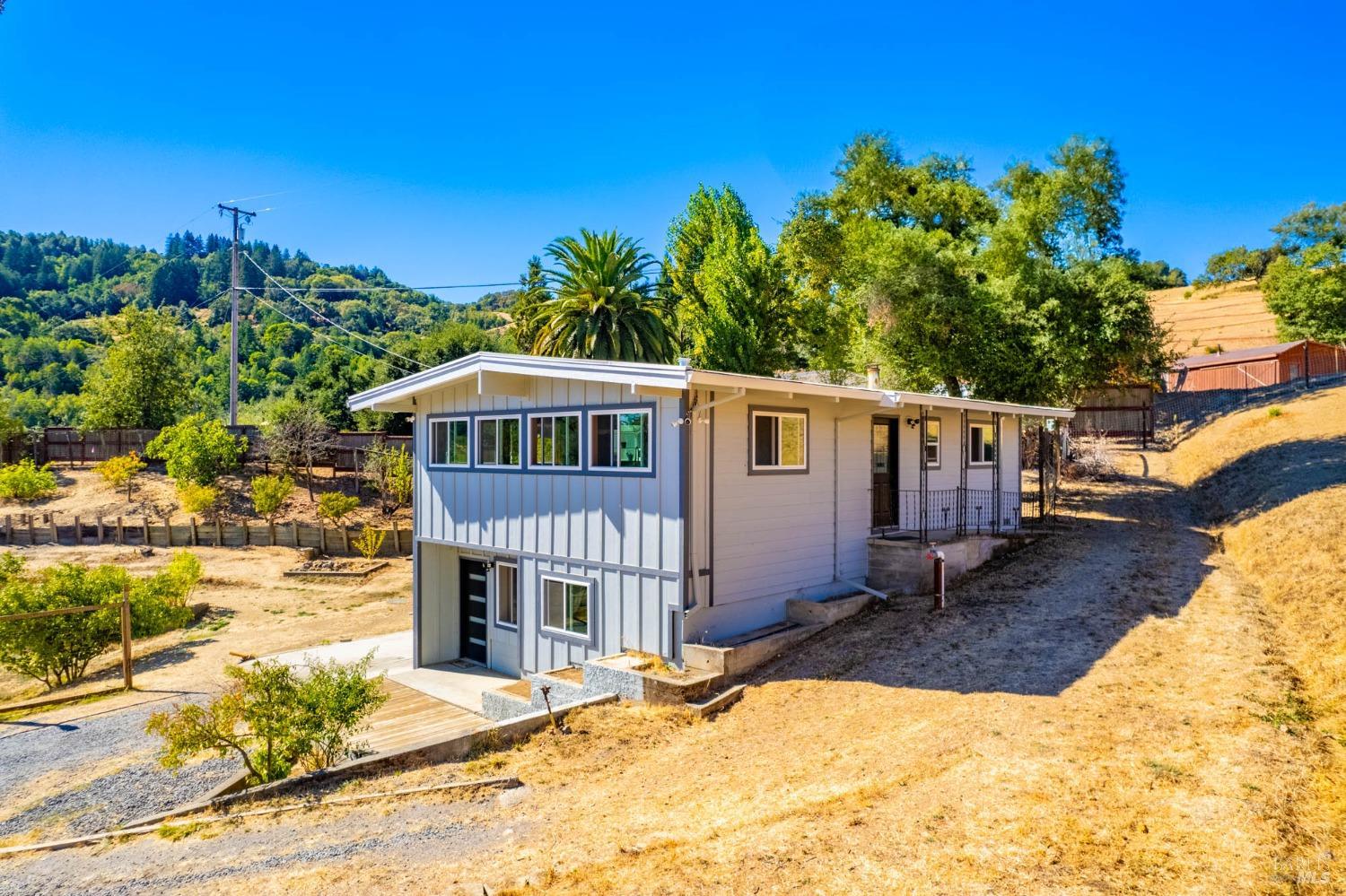 Discover peaceful country living just outside Cloverdale with this beautifully remodeled 2-bedroom, 1.5-bath home on 7.26 acres along scenic Highway 128. Enjoy breathtaking views into the Alexander Valley. Located just 10 minutes from downtown Cloverdale, 28 minutes to Healdsburg Plaza, and 90 minutes to the Golden Gate Bridge. Recent upgrades include new Hardie siding, doors, windows, roof, and interior finishes. The house offers a spacious 800sqft (in addition to the 1,112sqft) finished area downstairs with a separate entrance, perfect for a home office, guest space, etc. Outside, you'll find several fruit trees, lovely oak trees, and grassy meadows, plus a pool (ready for repair) and pool house/workshop. There's also a small single-room studio and ample land for expansion, including a potential second home site. A newer productive well provides domestic water for this property, including water storage, filtration, and a fire department standpipe near the house for fire protection. This property is a rare opportunity to create your dream retreat in wine country. (Please no drive-bys. Do not disturb occupants).