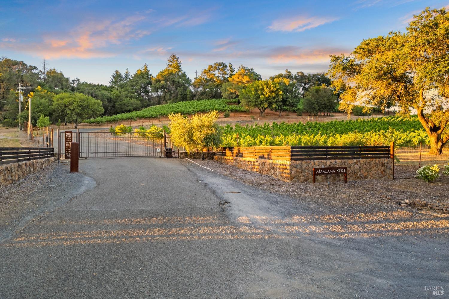 Located in the award-winning Alexander Valley of Healdsburg, California, this estate blends modern, sustainable architecture with privacy and luxury. The 4-bedroom, 3.5-bathroom carbon-neutral home sits on a gated 44-acre property within an exclusive community. About 8 acres are dedicated to income-producing Syrah and Petite Syrah vines, plus an olive orchard.  Every room is bathed in natural light, featuring floor-to-ceiling windows that capture stunning views of hills and vineyards. The interior boasts high-end finishes, including a chef's kitchen with custom walnut cabinets and granite countertops.  The secluded downstairs primary suite has a private entrance, soaring ceilings, built-in cabinets, and a spa-like bathroom with dual vanities, a free-standing tub, and a travertine-tiled shower. Three additional bedrooms, two full baths, and a media room are located upstairs.  Step outside to an expansive deck with a cook station, open-air fireplace, and a custom saltwater pool, offering an eco-friendly retreat.  The estate is fully self-sustaining, powered by solar, with three private wells and fire-safe water tanks. A detached building houses a garage, workshop, and secure storage, completing this off-grid masterpiece.