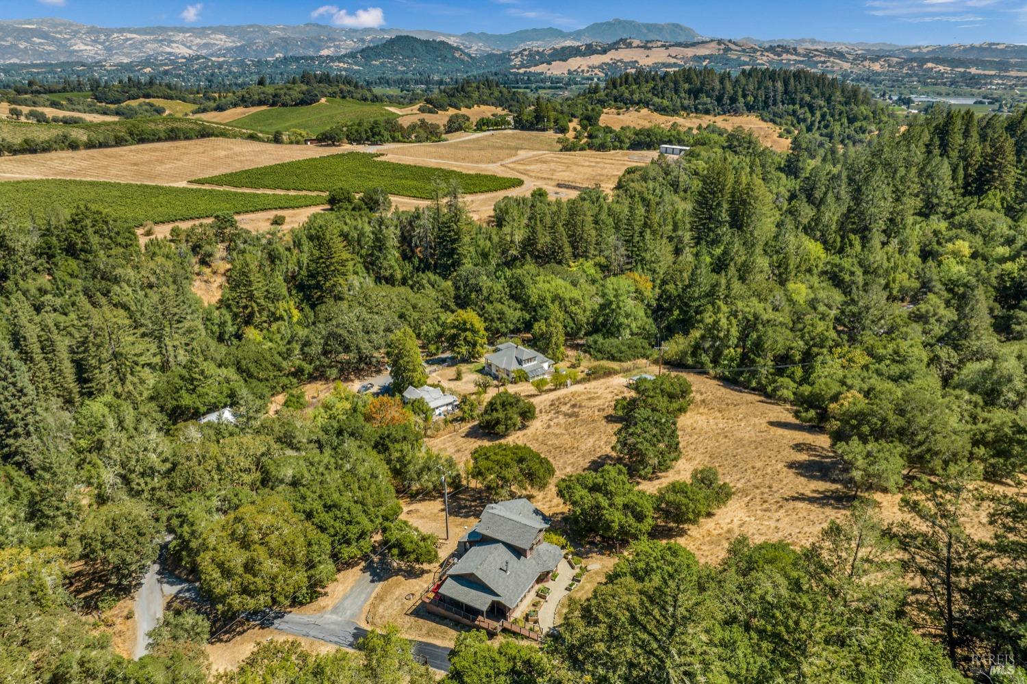 A serene retreat nestled on 12 acres in Dry Creek Valley, a short 10-min drive to charming Downtown Healdsburg. This exceptional property offers the perfect blend of tranquility & convenience, making it an ideal getaway or a self-sustaining homestead. The spacious home features an updated kitchen and primary bed/bath. An additional ensuite bedroom spans the entire second level, while a sunroom stretches across the south side of the home. Hardwood floors, high cathedral ceilings, and incredible views offer modern comforts amidst nature's beauty. The property boasts groves of majestic, mature redwoods & oak woodlands, graced by the year-round, spring-fed Mill Creek, which hosts spawning steelhead each spring. This picturesque creek provides a refreshing spot to cool off on warm summer days. Near the creek, a well-maintained barn and office provide versatile spaces, often used by the current owners for special entertaining occasions & wine tastings.    For outdoor lovers, the property offers ample walking or backcountry hiking right from your doorstep. A kitchen garden w/ raised beds is conveniently located near the home, complemented by over 4,000 SF of a fenced garden area, complete with a private water supply throughout. This is a rare offering in Sonoma County's wine country.