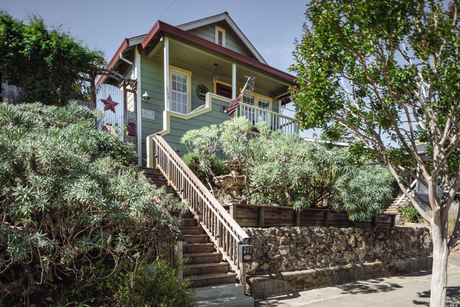 This beautifully preserved turn-of-the-century bungalow effortlessly blends timeless charm with modern comfort. Nearly every inch of this residence has been thoughtfully maintained and optimized for easy living. As you step inside, you're welcomed by a cozy living room with stunning oak hardwood floors and recessed lighting, seamlessly flowing into the dining area. The sweet kitchen boasts a gas range, classic wainscoting, leading to an enclosed back porch-a perfect space for a home office or entertaining. With two inviting bedrooms and a beautifully updated bathroom, the home also features an upgraded kitchen designed to suit contemporary tastes. The vintage appeal is further enhanced by an inviting front porch, elegant French doors, and a sunlit back room. Outside, the meticulously landscaped grounds provide a serene and private retreat, perfect for relaxation or hosting gatherings. A detached studio, ideal for use as an office, wellness space, or guest quarters, opens onto a picturesque setting, showcasing stunning hillside views. Nestled in a highly sought-after location, this home is just moments from top-rated schools, Downtown Petaluma and scenic hiking trails.