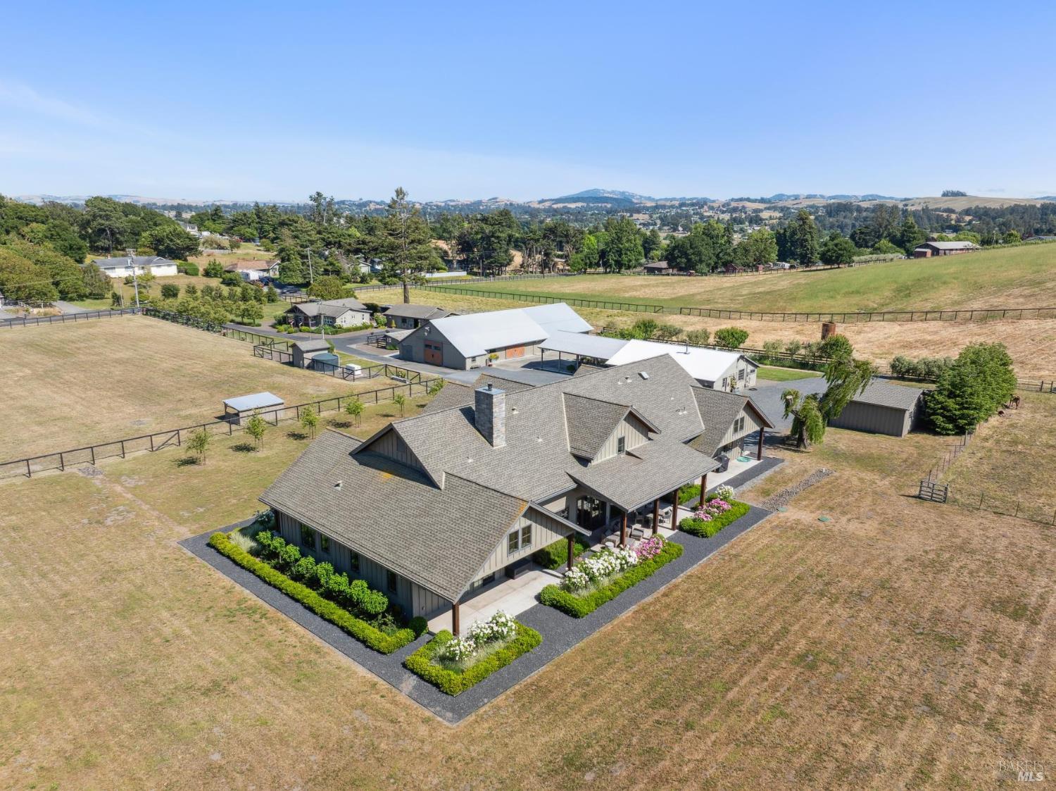 365 King Road Petaluma, California 365/369 King Road is a gated, 8-acre West Petaluma estate with panoramic views of Sonoma Mountain. The 3,878-SF main house features two en-suite bedrooms, a den/office, 2.5 bathrooms, a great room with open-beam ceilings and a gas fireplace, plus a chef's kitchen with an island and butler's pantry. The 1,200-SF guesthouse offers two bedrooms, two bathrooms, a fireplace, full kitchen, private deck, and separate laundry. Outdoor highlights include a two-stall horse barn and a fully fenced and cross-fenced property. The renovated milk barn with a wood-burning stove, full kitchen, and bathroom is currently used for entertaining and overnight guests. Additional barn accommodates equipment and mowers. Minutes from shops, restaurants, and trails, this estate blends rural beauty with modern living.