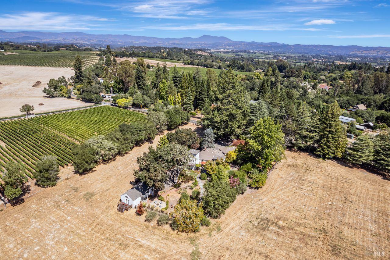 This true legacy property has remained in the same family since the 1930s and is set in the highly desirable Vine Hill region of Sebastopol, renowned for its Goldridge soils within the Russian River Valley appellation. The original farmhouse has been thoughtfully updated and expanded over the years, skillfully preserving its historic character and charm. The delightful kitchen addition is designed with tall ceilings as an architectural counterbalance to the original water tower. The dining room opens to the backyard deck, both featuring expansive westerly views of the enchanting grounds and hills beyond. The peaceful bedroom wing offers serene views. Windows enclose a porch creating an inspiring office space. The detached art studio is bathed in natural light and offers comfortable guest quarters. A spacious pergola, elegantly wrapped in mature wisteria and illuminated by string lights, serves as the perfect setting for gatherings. The enchanting grounds surrounding the home are beautifully landscaped, showcasing grand trees such as Japanese Maple, Oak, Olive, and various fruit trees. This year, 16-acres of Chardonnay and Pinot vines, originally planted in 1995, have been removed. This alluring, over 19-acre parcel in a timeless setting offers a rare and exceptional opportunity.